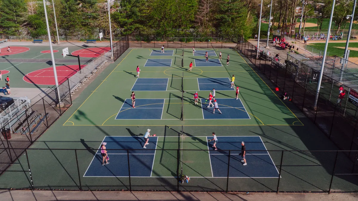 Vue aérienne de courts de pickleball extérieurs avec des joueurs en partie