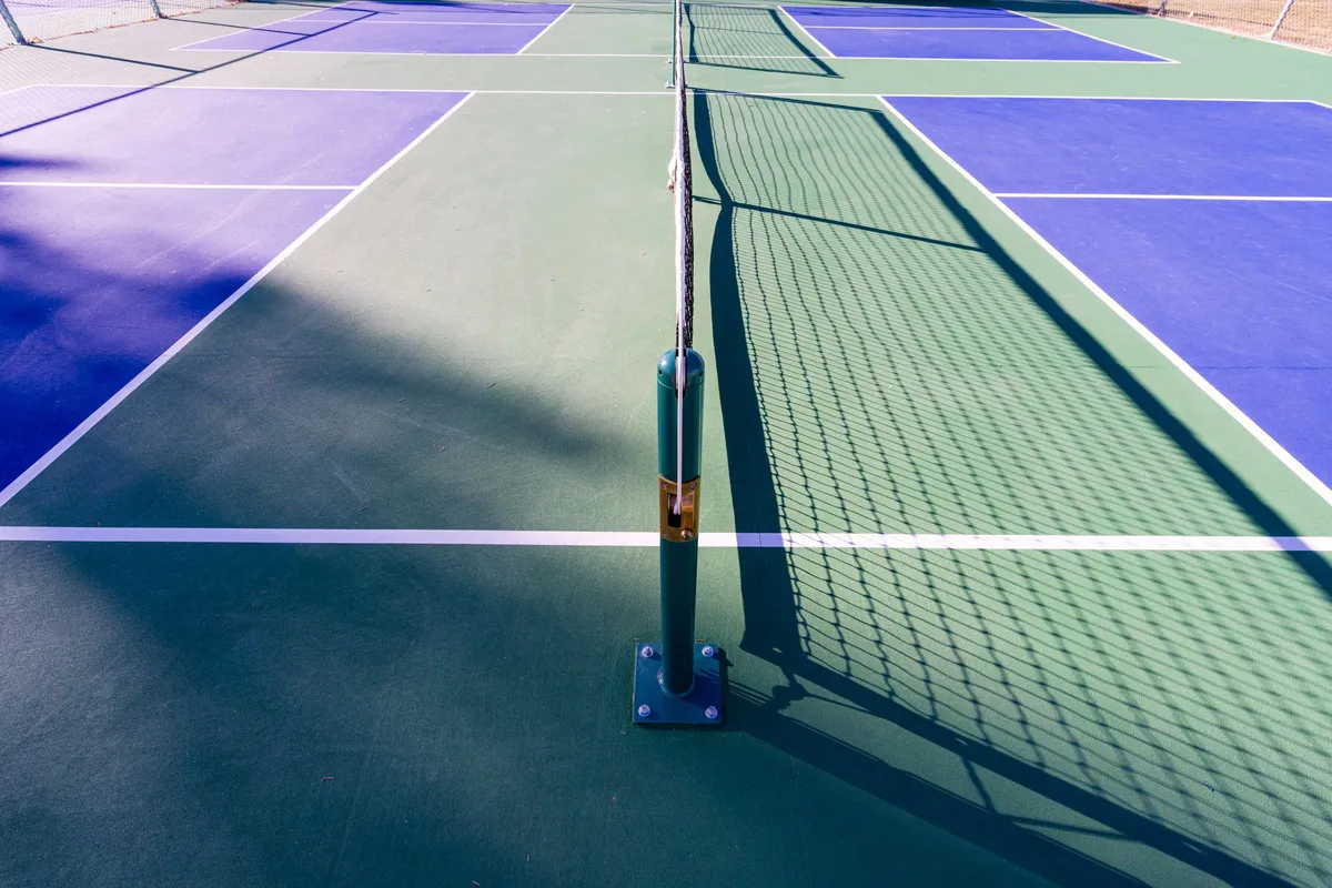 Poteau et filet d’un court de pickleball extérieur au soleil